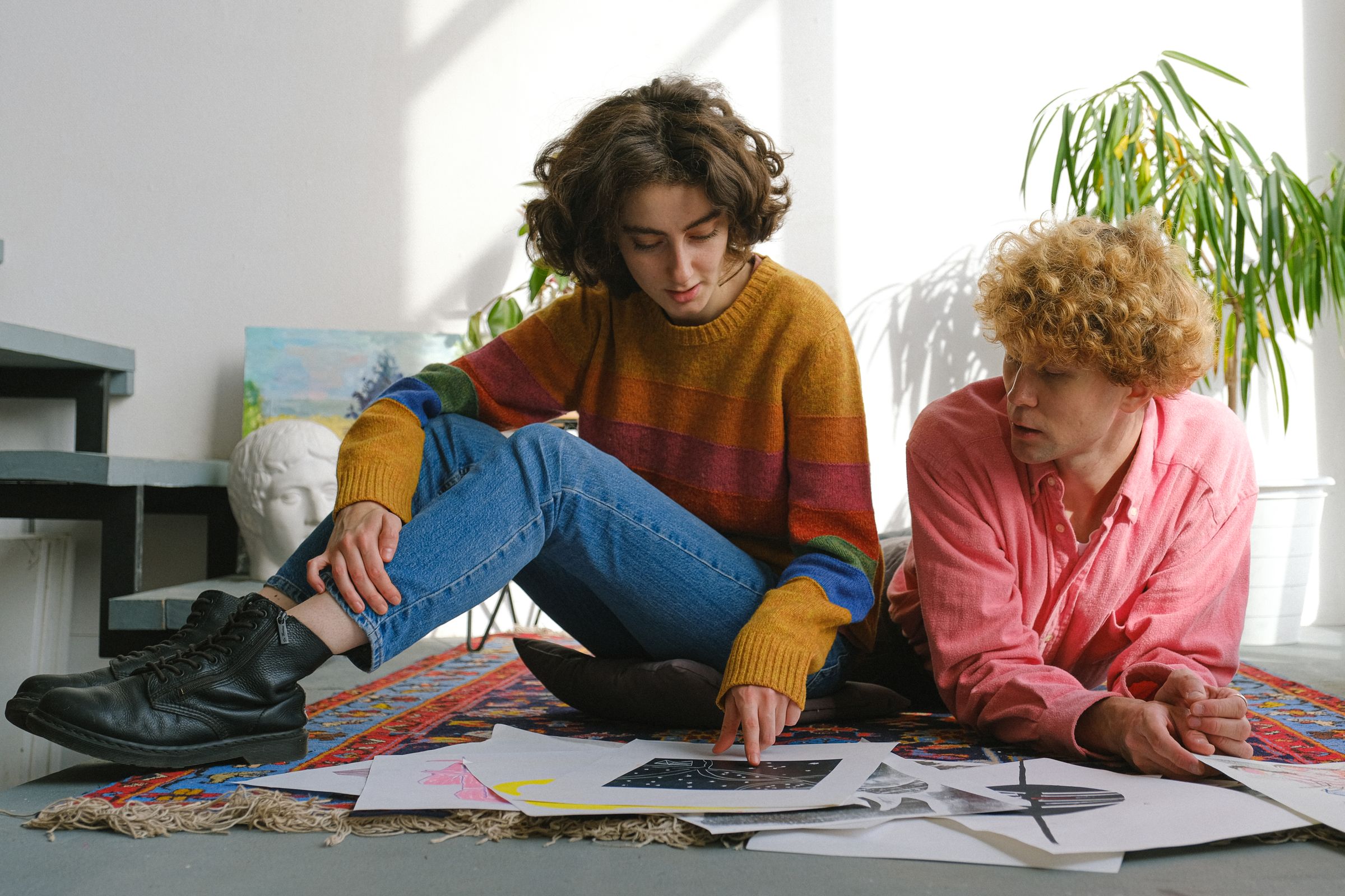 Young designers discuss sketches and the structure of a digital product around a worktable