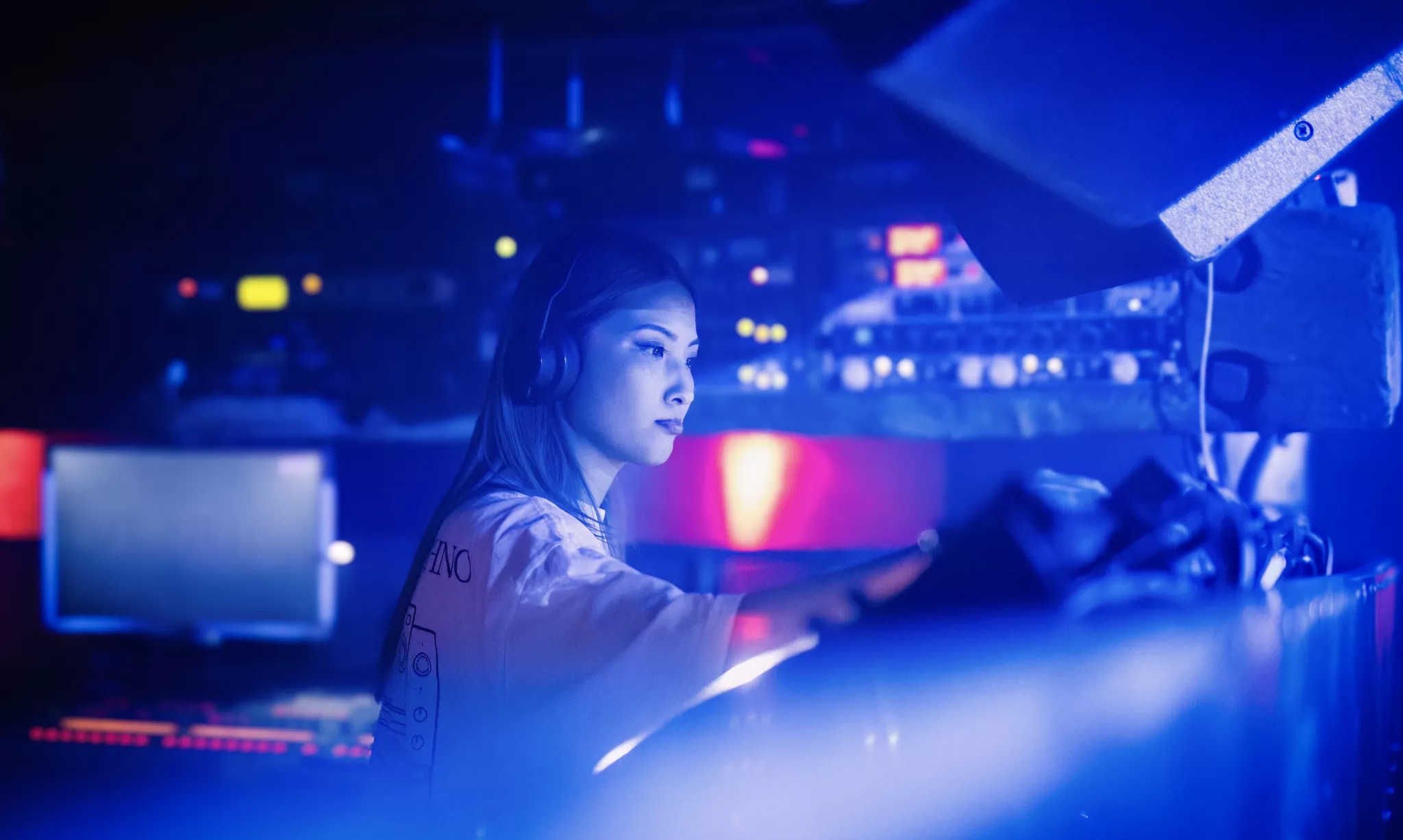 A student performs a DJ set on professional decks in a club-style teaching space