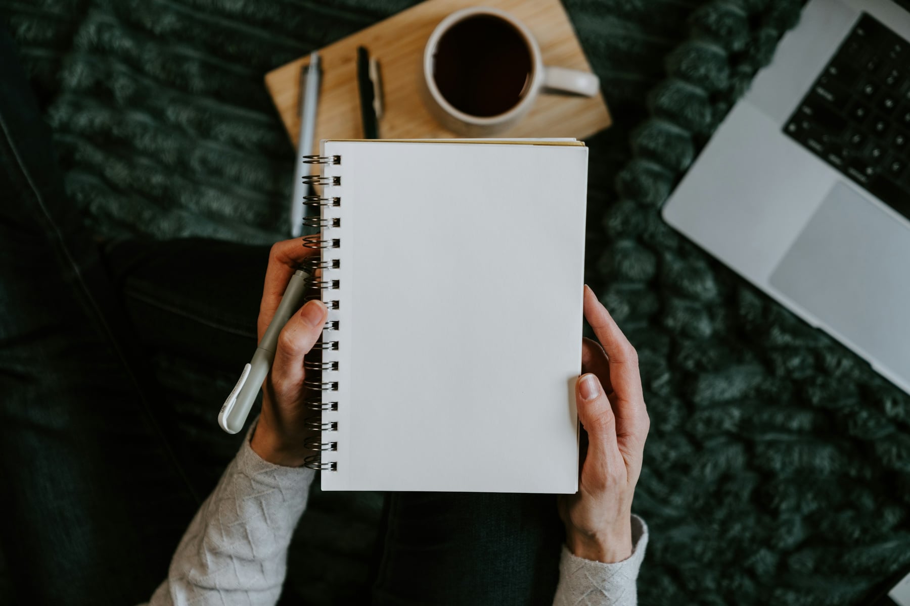 An applicant holding a notebook beside a laptop while planning application deadlines
