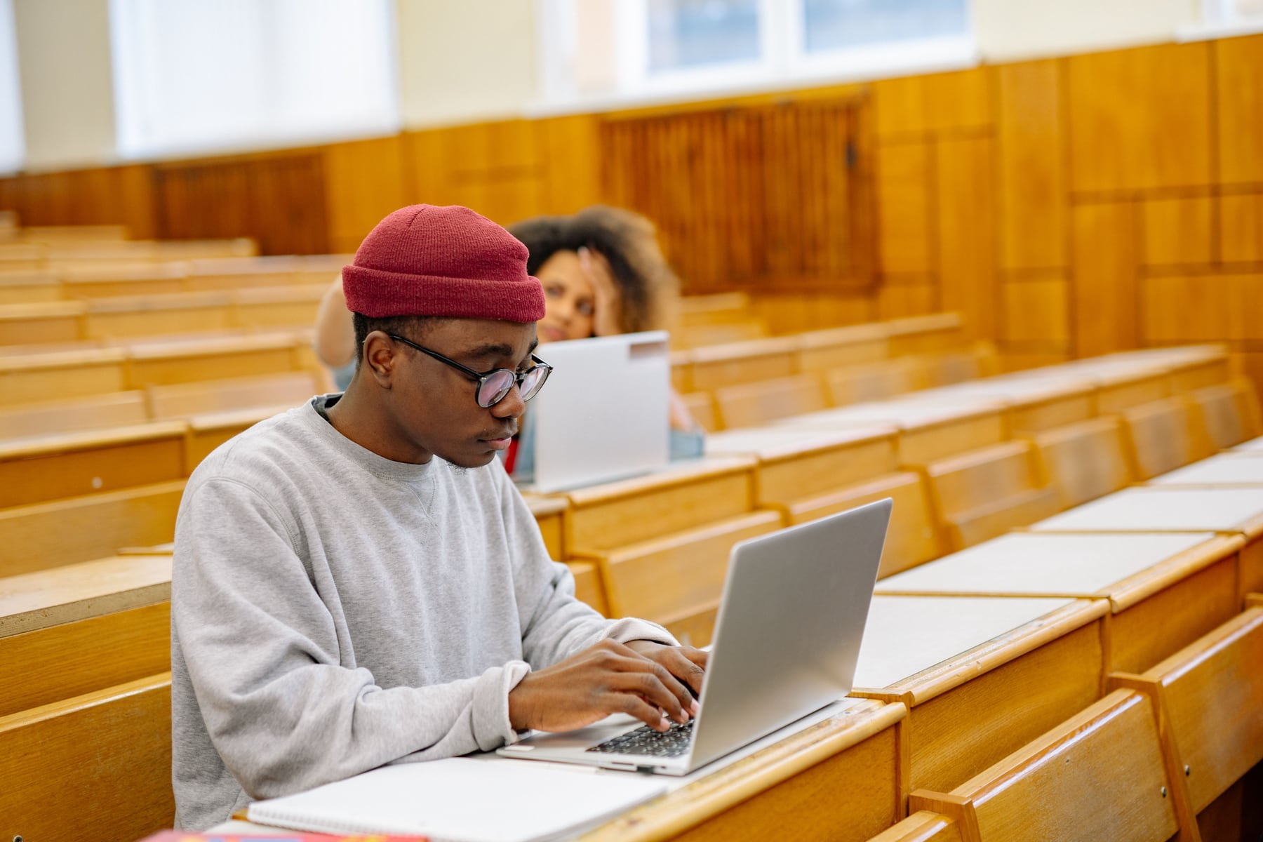 Students with laptops listening to a lecturer in a university lecture theatre