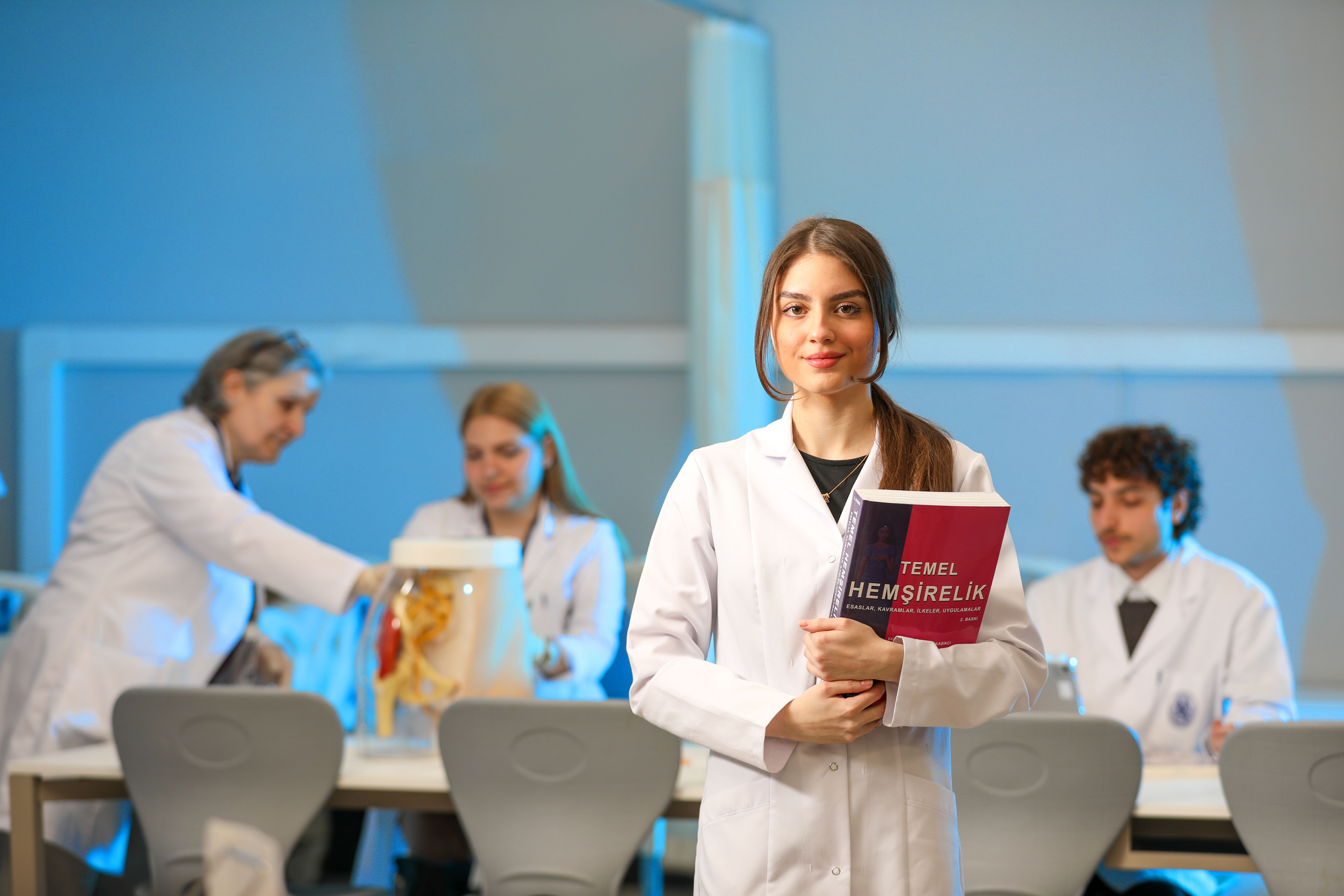 Four university nursing students in a practical teaching laboratory, with every head fully visible