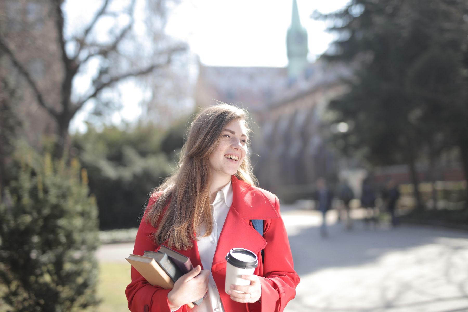 A student carrying books on a university campus in Prague